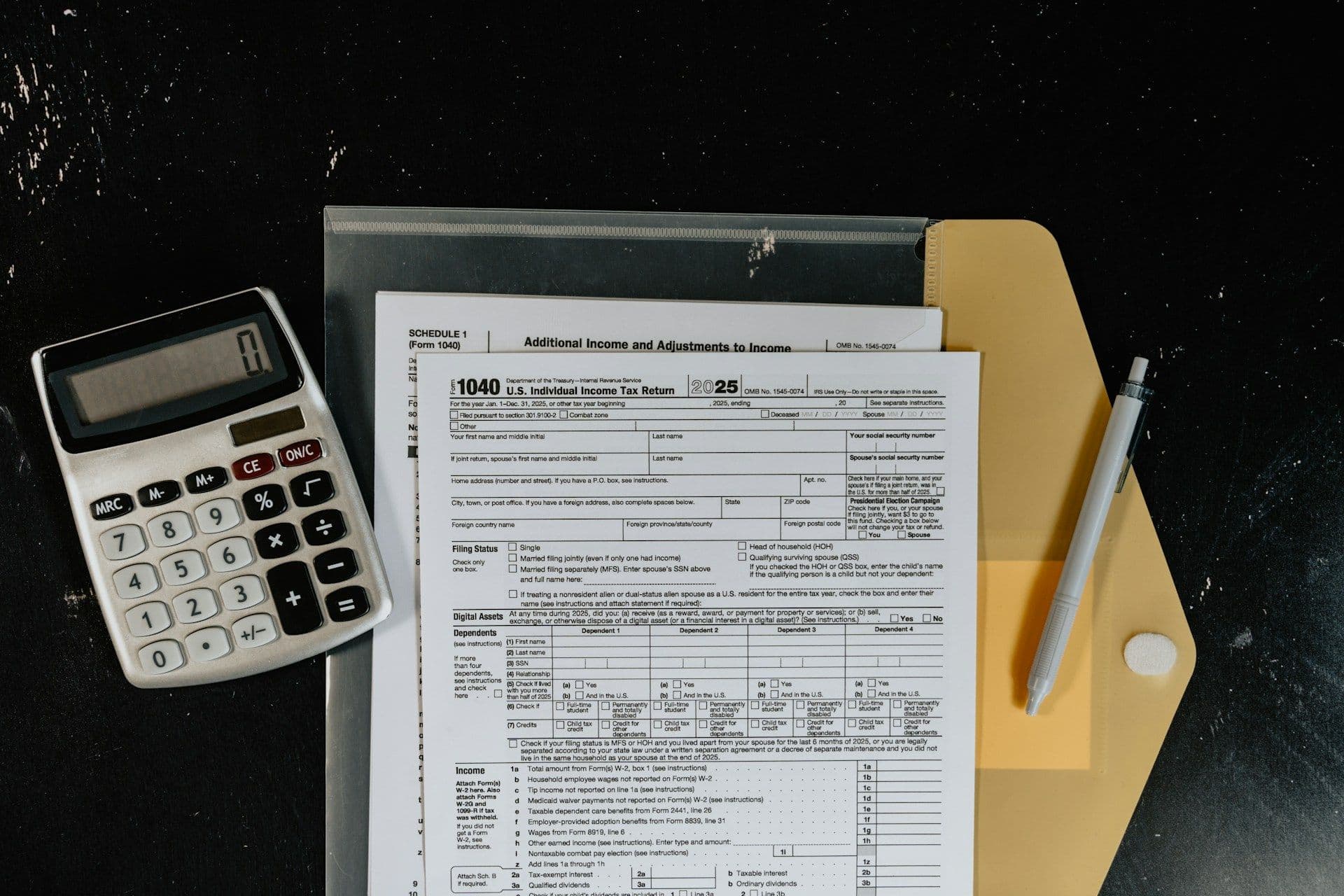 Calculator and tax forms on a dark surface